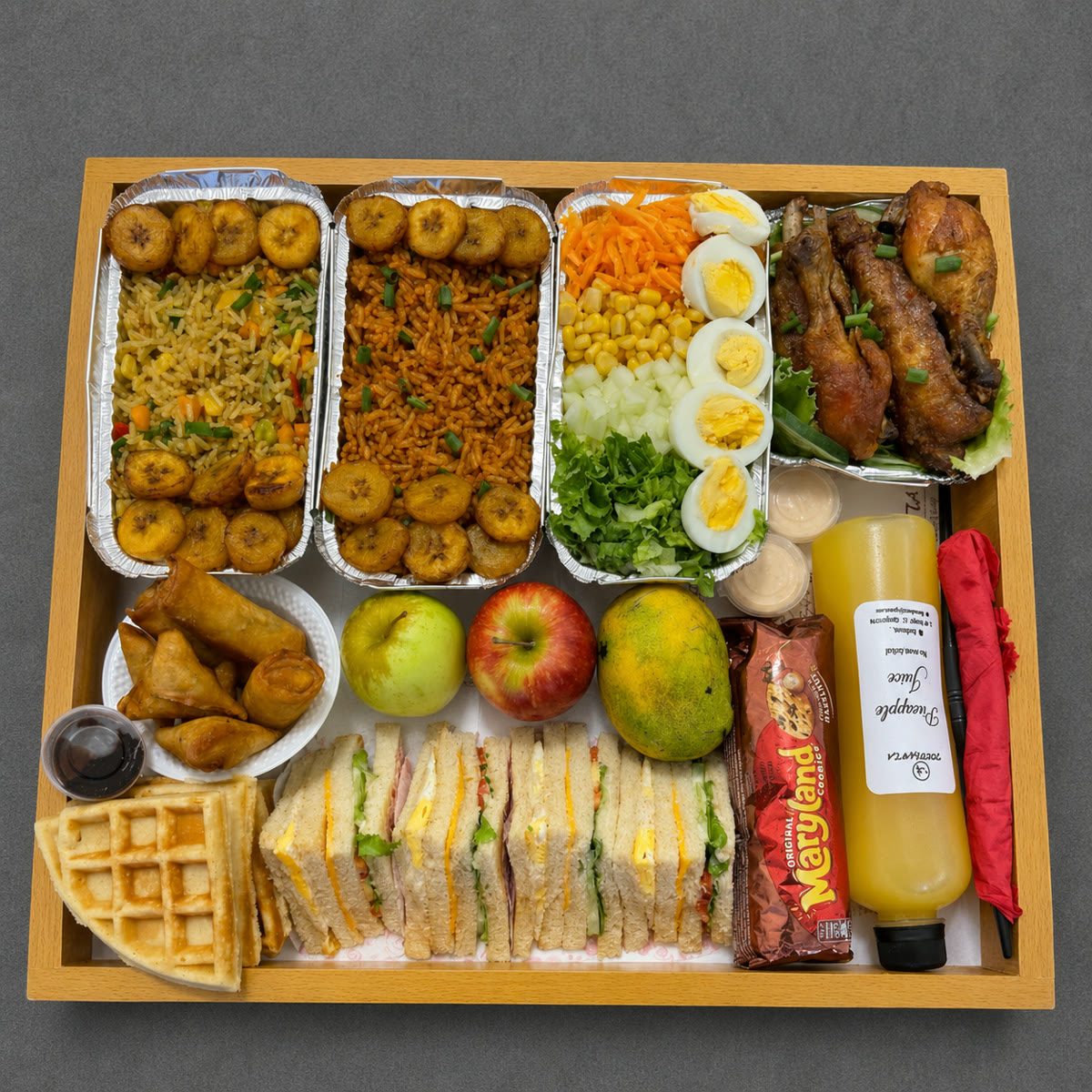 Surprise food tray with rice, plantain, chicken, sandwiches, fruit and a drink